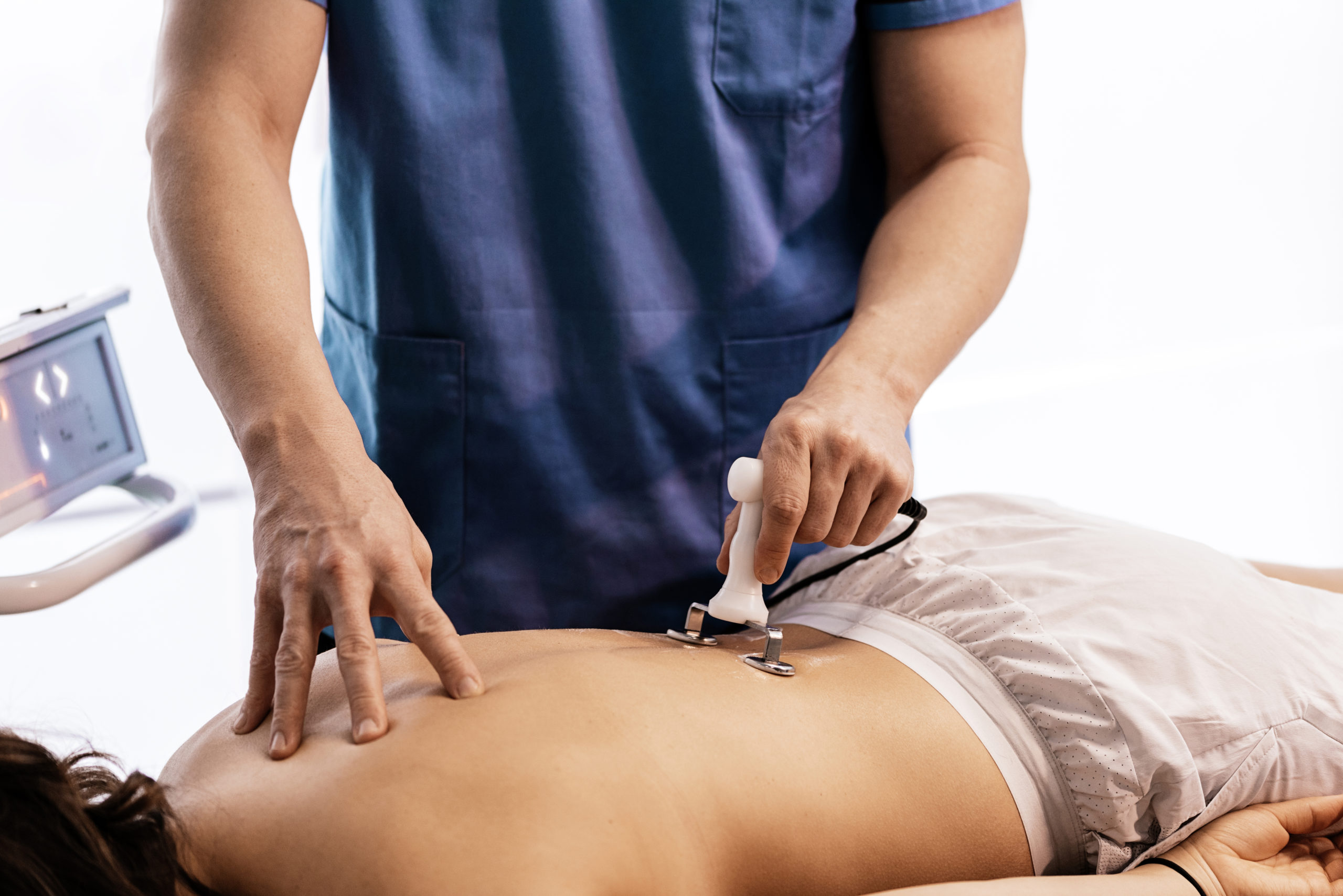 Physiotherapist giving backstroke therapy to a woman in clinic. Physical treatment concept